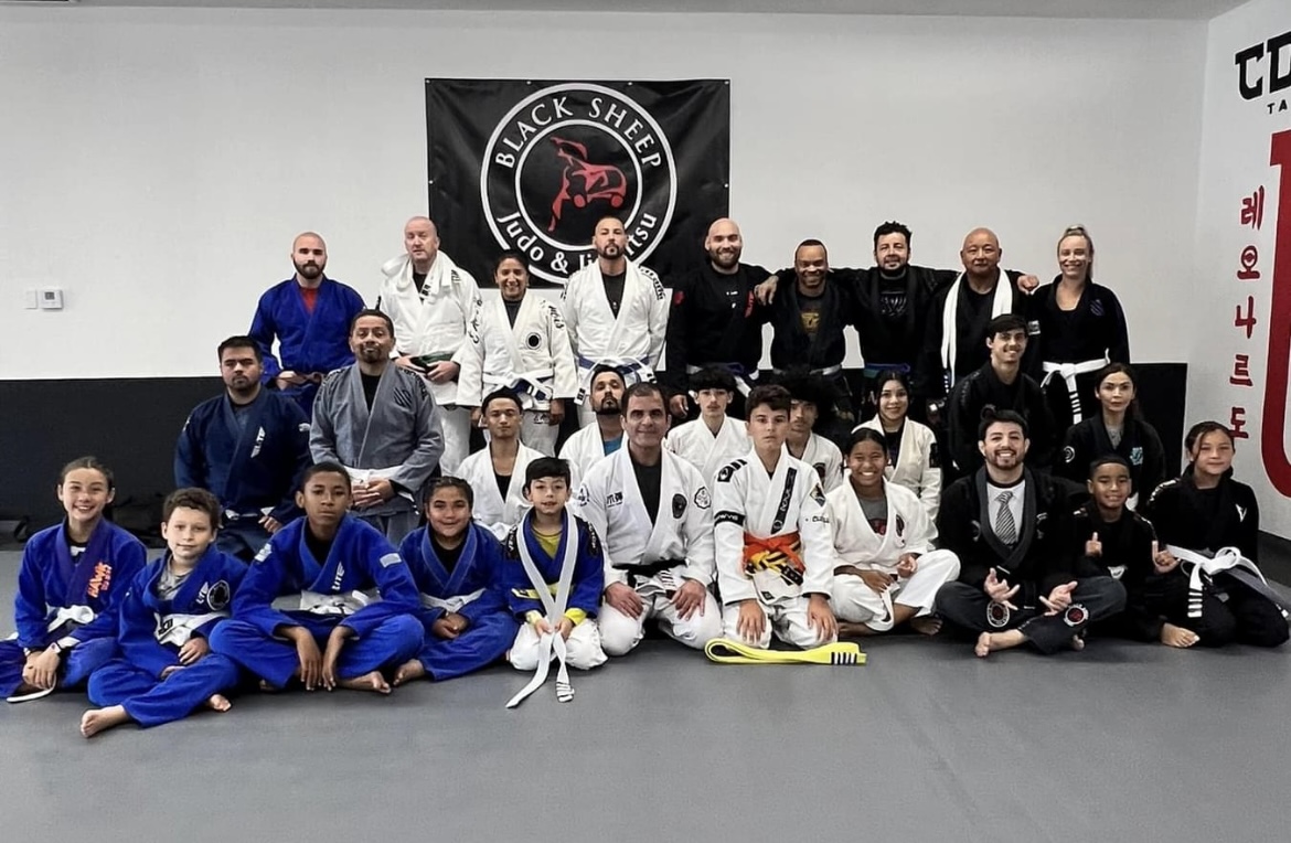 Group photo of Black Sheep Judo & Jiu Jitsu members in their gi, standing on mats in the dojo